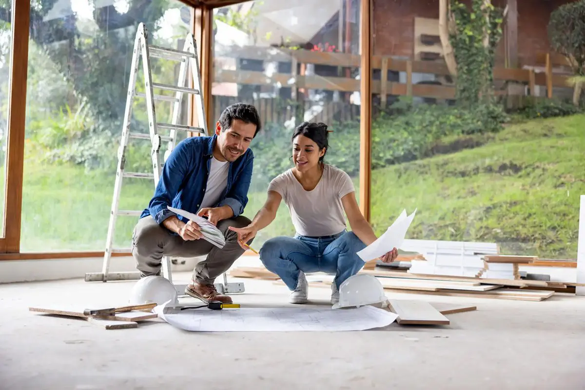 Couple reviewing home plans together indoors during renovation.