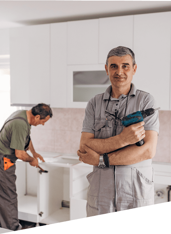 Two men working on kitchen cabinets.