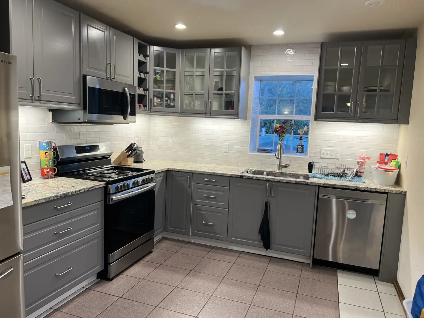 Modern kitchen with gray cabinets and stainless steel appliances.